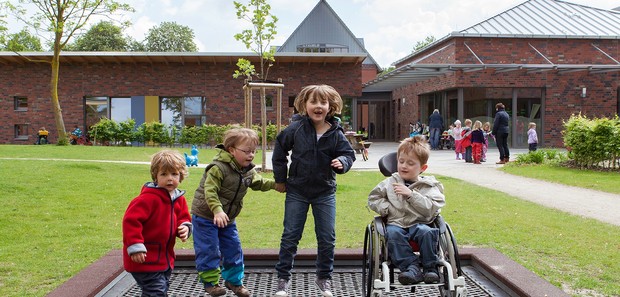 Spielende Kinder vor einer Kindertageseinrichtung